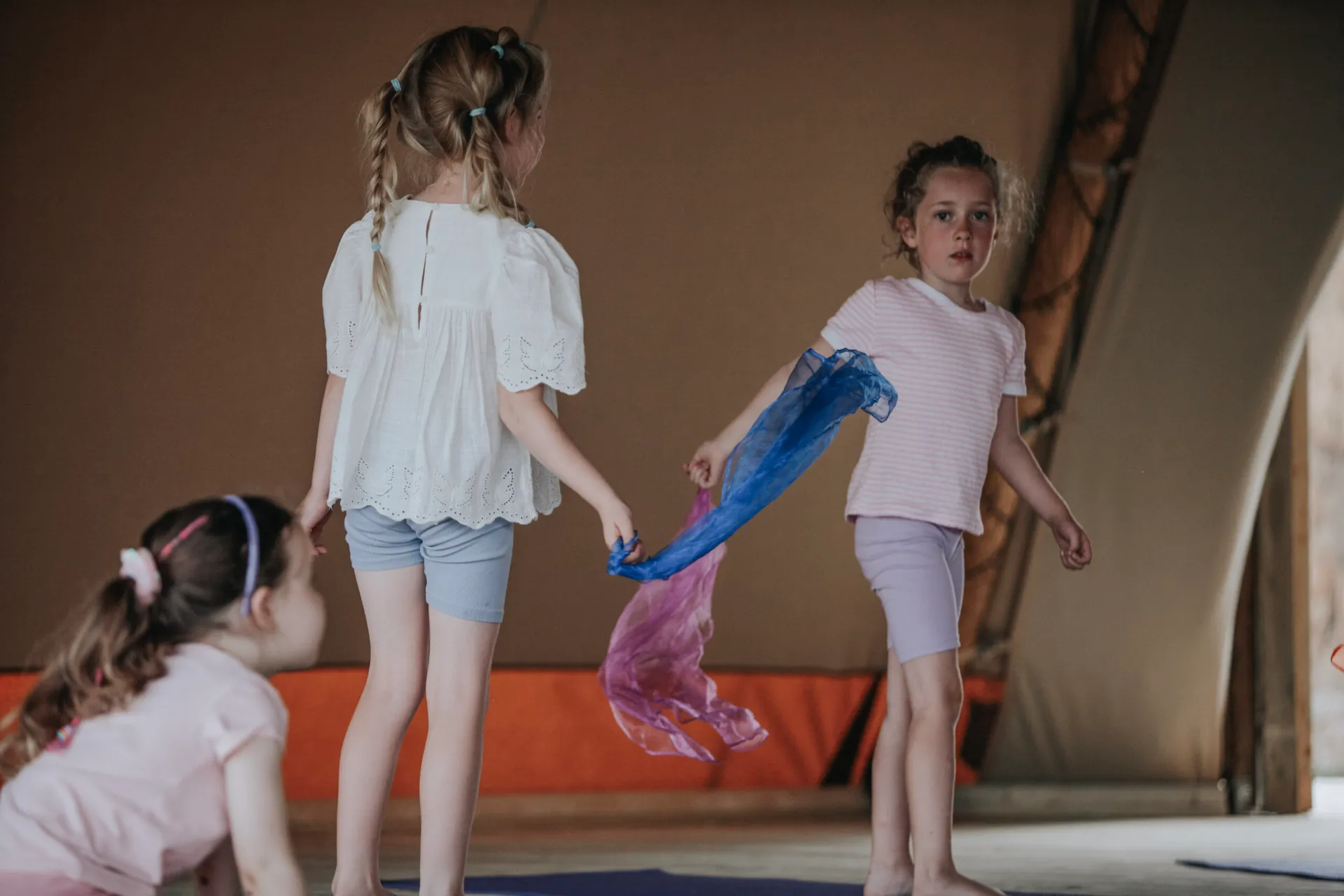 Children playing with a scarf during a Happy Kids Yoga class