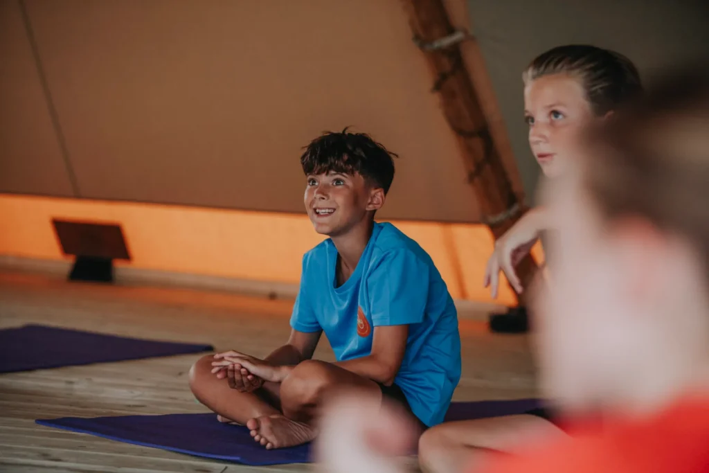 Two boys sitting cross legged during a yoga class