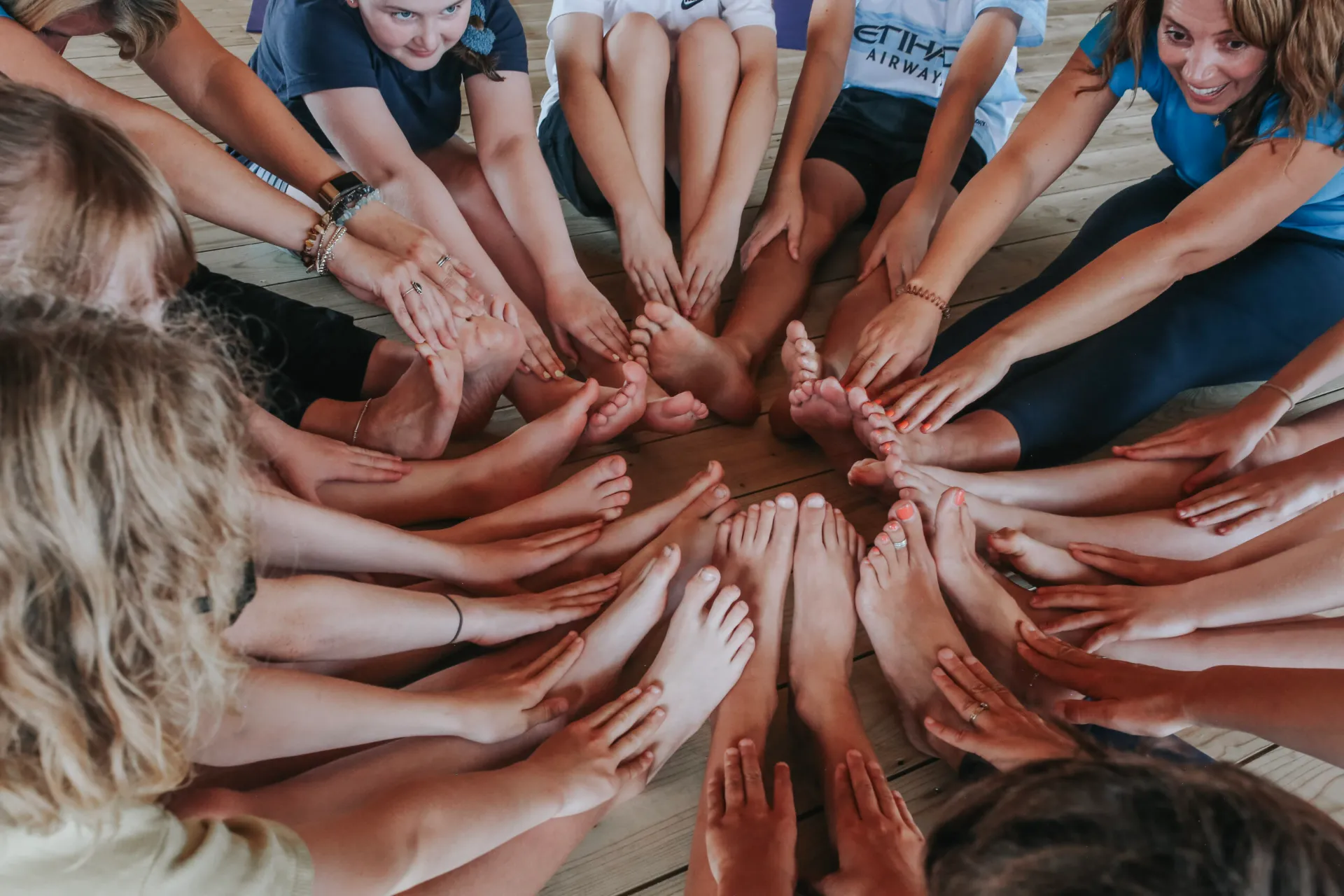 Children and teachers placing their hands together in a circle