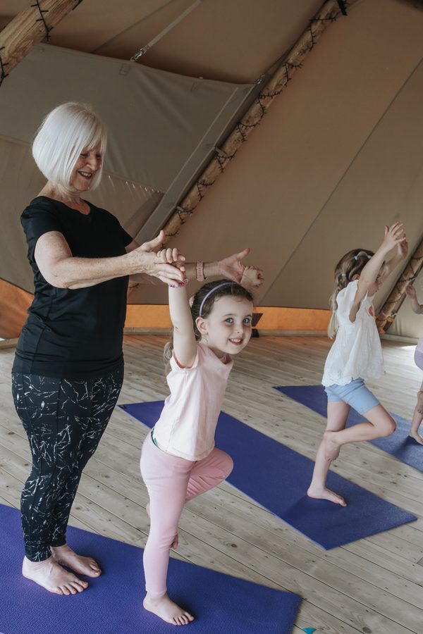 A grandparent and a small child balancing on one leg together